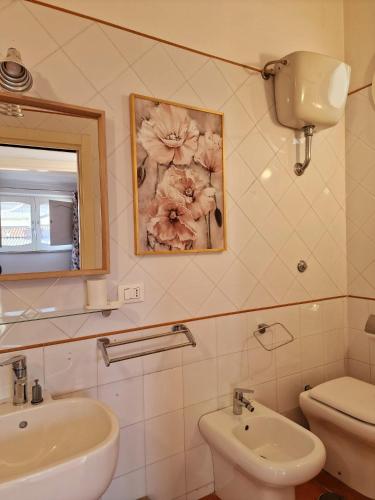 Un baño con lavabo, inodoro y espejo. en LA TERRAZZA HOME, en Caserta