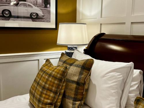 a bedroom with a bed with two pillows and a lamp at The Wrea Head Hall Country House Hotel & Restaurant in Scarborough