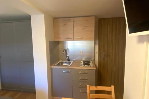 a small kitchen with a sink and a counter at Rössli Self Check in 24-7 Free Parking in Unterägeri
