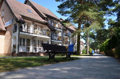 a park bench sitting in front of a building at Ośrodek Wypoczynku i Rekreacji Venus in Mrzeżyno