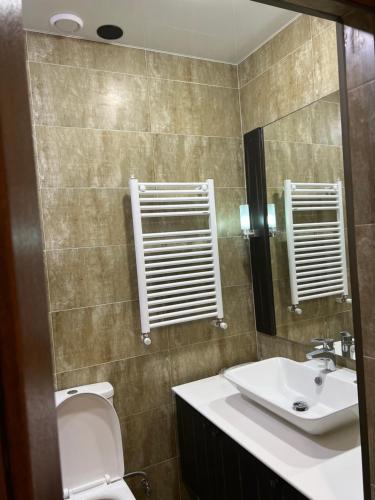 y baño con lavabo, aseo y espejo. en Green Hotel ANG, en Telavi