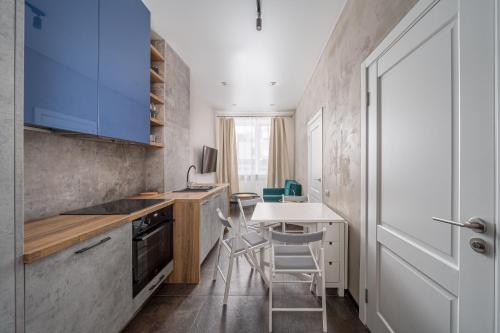 a kitchen with blue cabinets and a table and chairs at Peaceful 1-bedroom apartment in 100m from Beach, Free Street Parking, Near Forest Park in Jūrmala