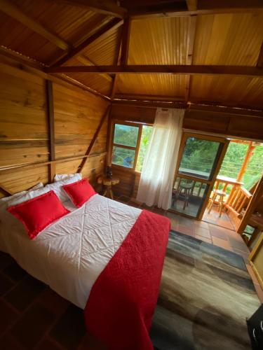 a bedroom with a bed in a room with windows at CABAÑA LOS NOGALES in San Agustín