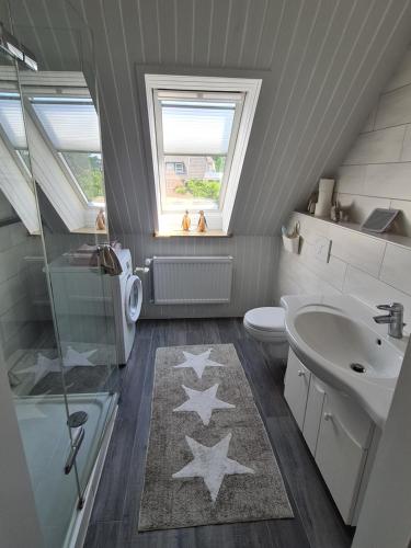 ein Badezimmer mit einem Waschbecken und einem WC mit Sternen auf dem Boden in der Unterkunft Apartment Seaside in Husum