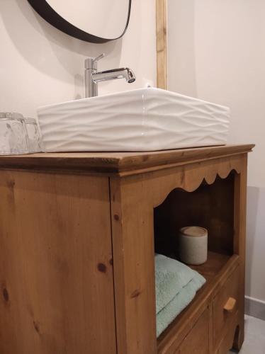 a bathroom sink sitting on top of a wooden cabinet at Le Grenier - Chambre d'hôtes in Thusy