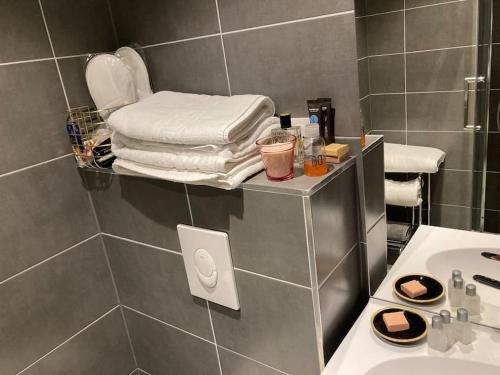 een badkamer met een wastafel en een aanrecht met handdoeken bij « Le Val d AuRS »Calme et élégance in Straatsburg