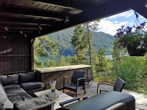a patio with a couch and chairs and a large window at Gjestehus i Sogndal in Sogndal