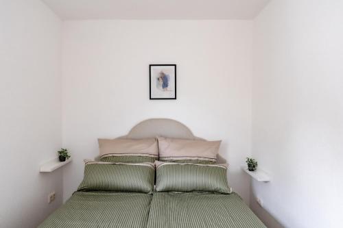 een slaapkamer met een bed met 2 kussens bij West48 Gemütliches Apartment -Blick auf Blauen See in Duisburg