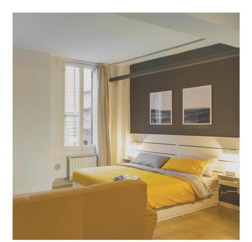 sypialnia z żółtym łóżkiem i oknem w obiekcie Appartamento Via delle Idee w Bolonii