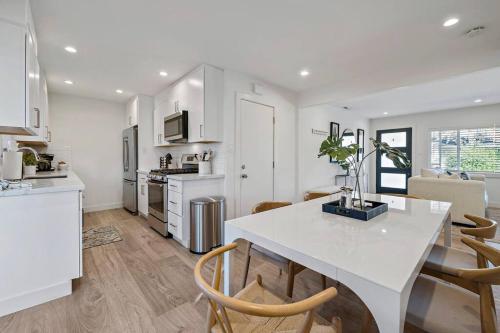 a white kitchen with a white table and chairs at Chic and Comfy Home in the Heart of Silicon Valley in Mountain View
