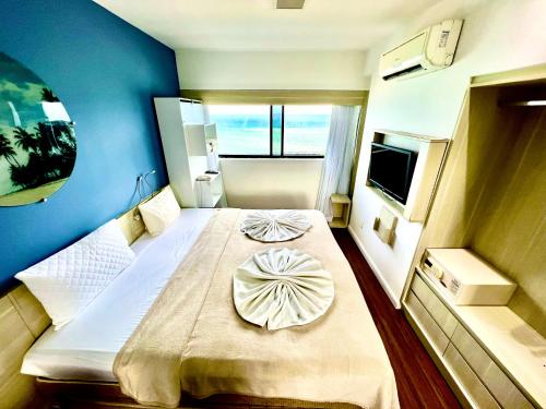 - une chambre avec un grand lit et un mur bleu dans l'établissement HOTEL NAVEGANTES VISTA PARA MAR Boa Viagem, à Récife