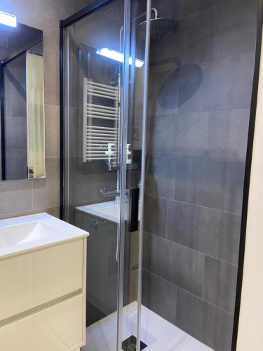 uma casa de banho com uma cabina de duche em vidro e um lavatório. em La Portella em Pas de la Casa