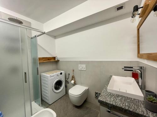 bagno con lavandino e servizi igienici e lavatrice. di Maison Etoile - Pila n 0042 a Pila