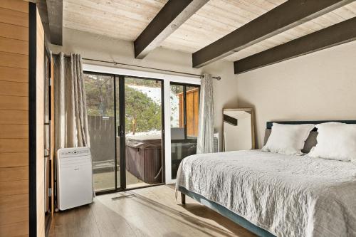 a bedroom with a bed and a sliding glass door at First Class Location in Big Bear Lake