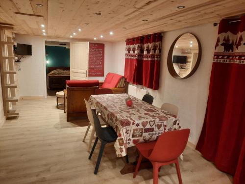une pièce avec une table et des chaises et une chambre dans l'établissement le face au tremplin Appartement 5 pers entièrement rénové dec 2022 classé meublé de tourisme 3 étoiles emplacement unique a Autrans proche du village prestations de qualité, à Autrans