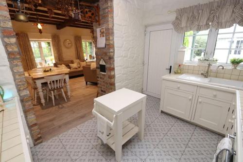 a kitchen with a sink and a table in a room at Doon Cottage Sleeps 8 Hottub Gym Area Pool Table in Tempo