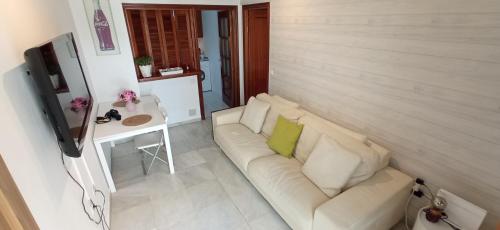 a living room with a white couch and a table at Apartamento Dueñas in Seville