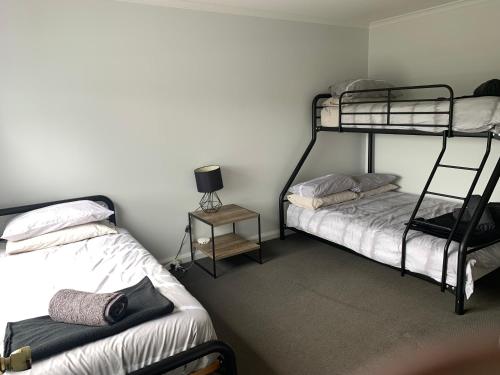 a room with two bunk beds and a table with a lamp at Derby Digs Cottage in Derby