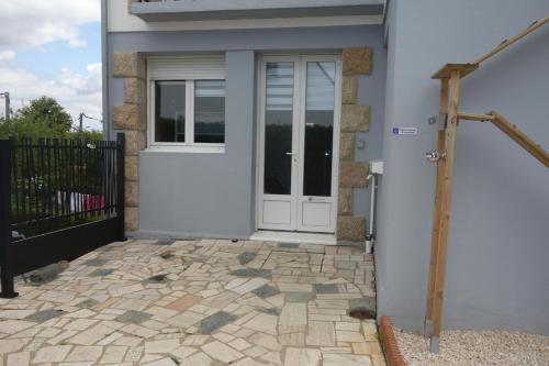 a white door on a house with a stone patio at Update Location in Lanester
