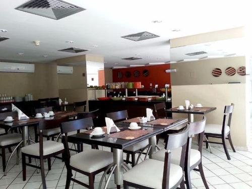 une salle à manger avec des tables et des chaises dans un restaurant dans l'établissement HOTEL NAVEGANTES VISTA PARA MAR Boa Viagem, à Récife