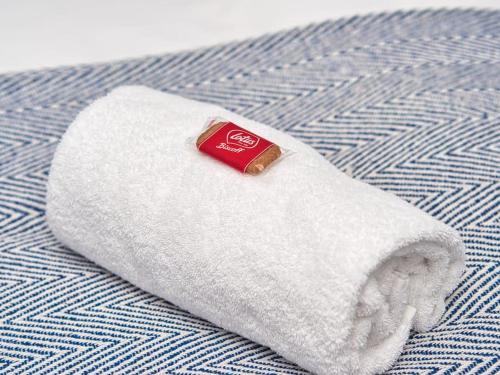 a white towel with a can of coke on a bed at *Sleeps 9* Modern, 4 Bed House, Birmingham in Birmingham