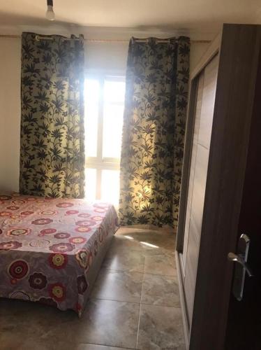 ein Schlafzimmer mit einem Bett in einem Zimmer mit einem Fenster in der Unterkunft مدينتي in Madinaty