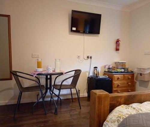 a room with a table and two chairs and a bed at Donkey & buskins in Layer de la Haye
