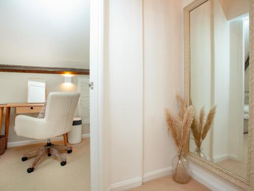 an office with a white chair and a mirror at Upper Forge in Malborough