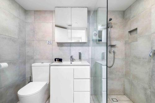 a bathroom with a toilet and a sink and a shower at Bay View in Tweed Heads