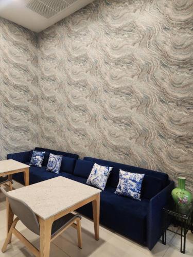 a blue couch in a living room with a wall at August Residence in Bangkok