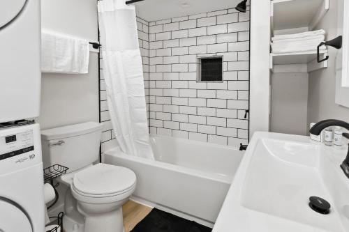 Baño blanco con aseo y lavamanos en Cozy Ba Townhome Near Little Italy I Fells Point en Baltimore