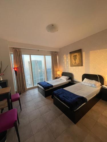 a bedroom with two beds and a large window at Travelers Backpackers in Dubai