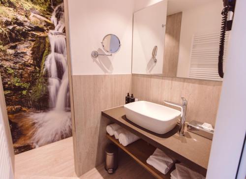 a bathroom with a sink and a mirror at Hotel Libertas elements pure in Freiburg im Breisgau