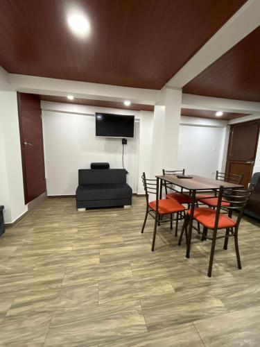 a conference room with a table and chairs and a screen at Bello apartamento en Baños de Agua Santa in Baños