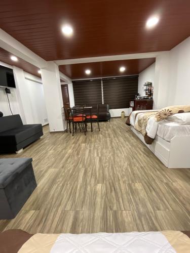 a room with a bed and a table and chairs at Bello apartamento en Baños de Agua Santa in Baños