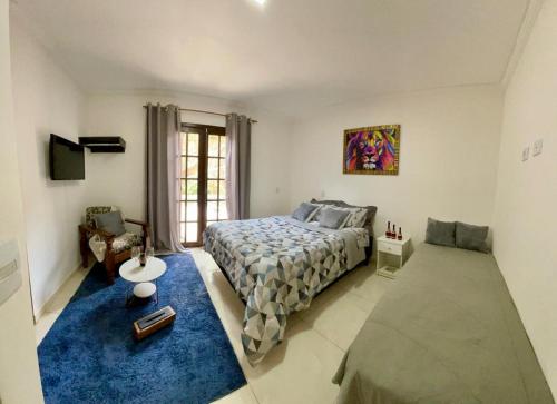 Un dormitorio con una cama grande y una alfombra azul en Mountain memory, en Campos do Jordão