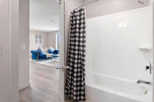 La salle de bains est pourvue d'un rideau de douche et d'une baignoire. dans l'établissement Luxurious&modern with balcony on the charles River, à Boston