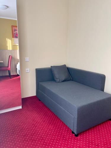 a couch in a room with a red carpet at Palm Premium Hotel & Apartments in Düsseldorf