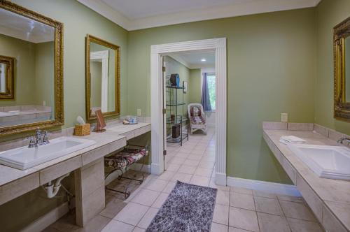 a bathroom with two sinks and a large mirror at The Inn at Cedar Grove in Vicksburg