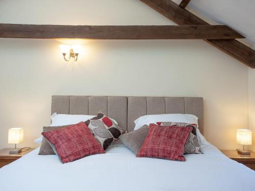 a bedroom with a white bed with pillows on it at Dunstone Cottage in Shaugh Prior