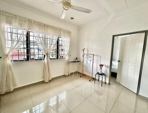 a living room with a ceiling fan and windows at Ipoh Deluxe Family Home in Ipoh