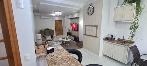 a kitchen and living room with a tv in a room at Excelente Apartamento Alto Padrão Centro Ed Dubai in Capão da Canoa