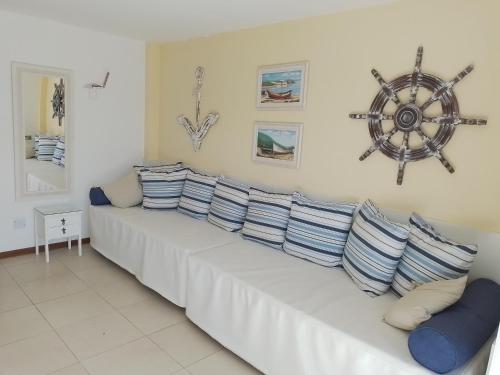 una fila de almohadas en un sofá en una habitación en Praia Grande- Villa da Praia - Cobertura Duplex!, en Arraial do Cabo