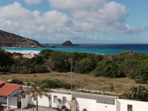 una casa con vistas a la playa y al océano. en Praia Grande- Villa da Praia - Cobertura Duplex!, en Arraial do Cabo