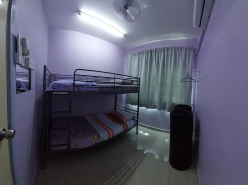 um pequeno quarto com 2 beliches e um chuveiro em Homestay Warisan Violet em Malaca