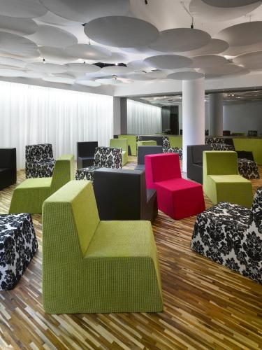 a waiting room with colorful chairs and tables at MOODs boutique hotel in Prague