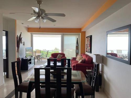 a living room with a table and a red couch at 8th Floor Villa Magna Condo in Nuevo Vallarta 
