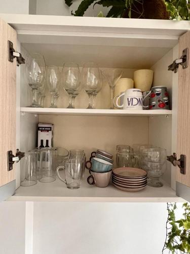 a shelf with wine glasses and dishes on it at Excelente Apartamento Alto Padrão Centro Ed Dubai in Capão da Canoa