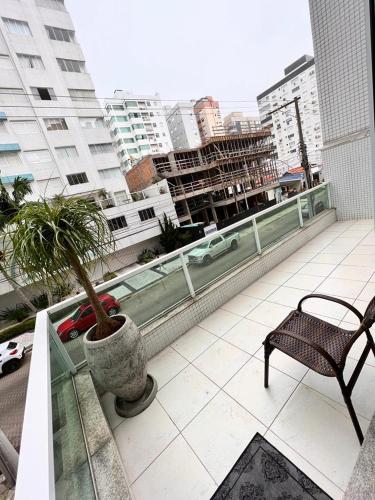 a balcony with a chair and a potted plant at Excelente Apartamento Alto Padrão Centro Ed Dubai in Capão da Canoa