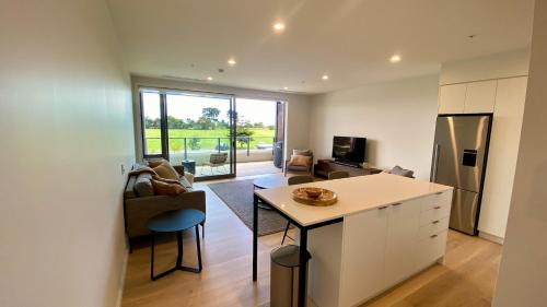 a kitchen and living room with a counter and a table at Tahuna Beach Apartment in Nelson